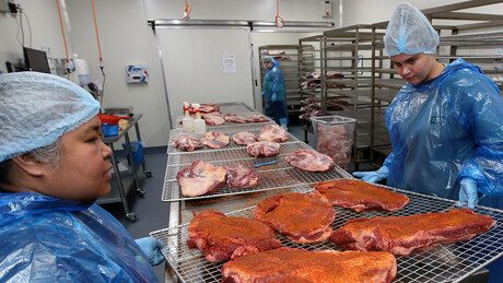 Applying the rub to the meat at Texas BBQ Foods