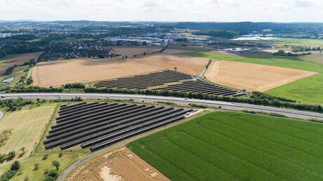 Large photovoltaic park nestling in the hilly verdant landscape – a symbol for the use of climate-friendly energy and a sustainable compressed air supply.
